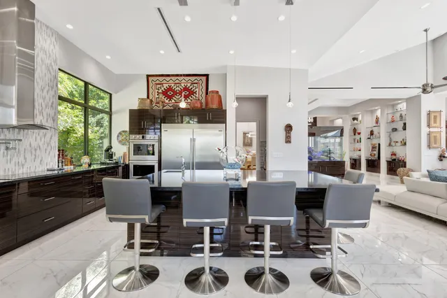 a dining room with furniture floor to ceiling windows and a flat screen tv