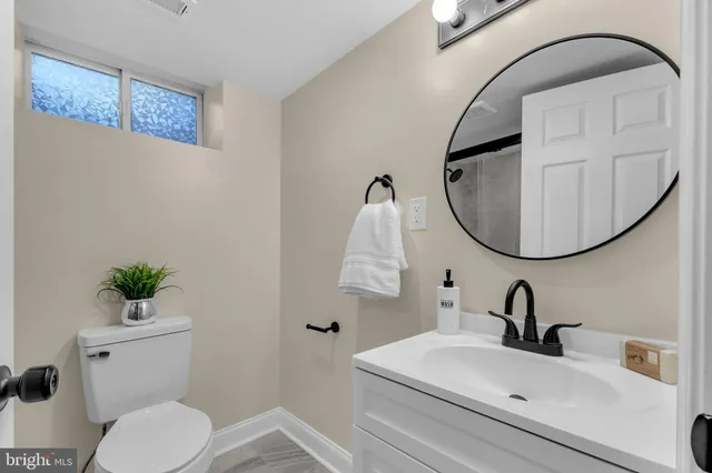 a bathroom with a sink mirror and toilet