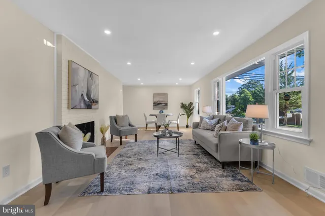 a living room with fireplace furniture and a large window