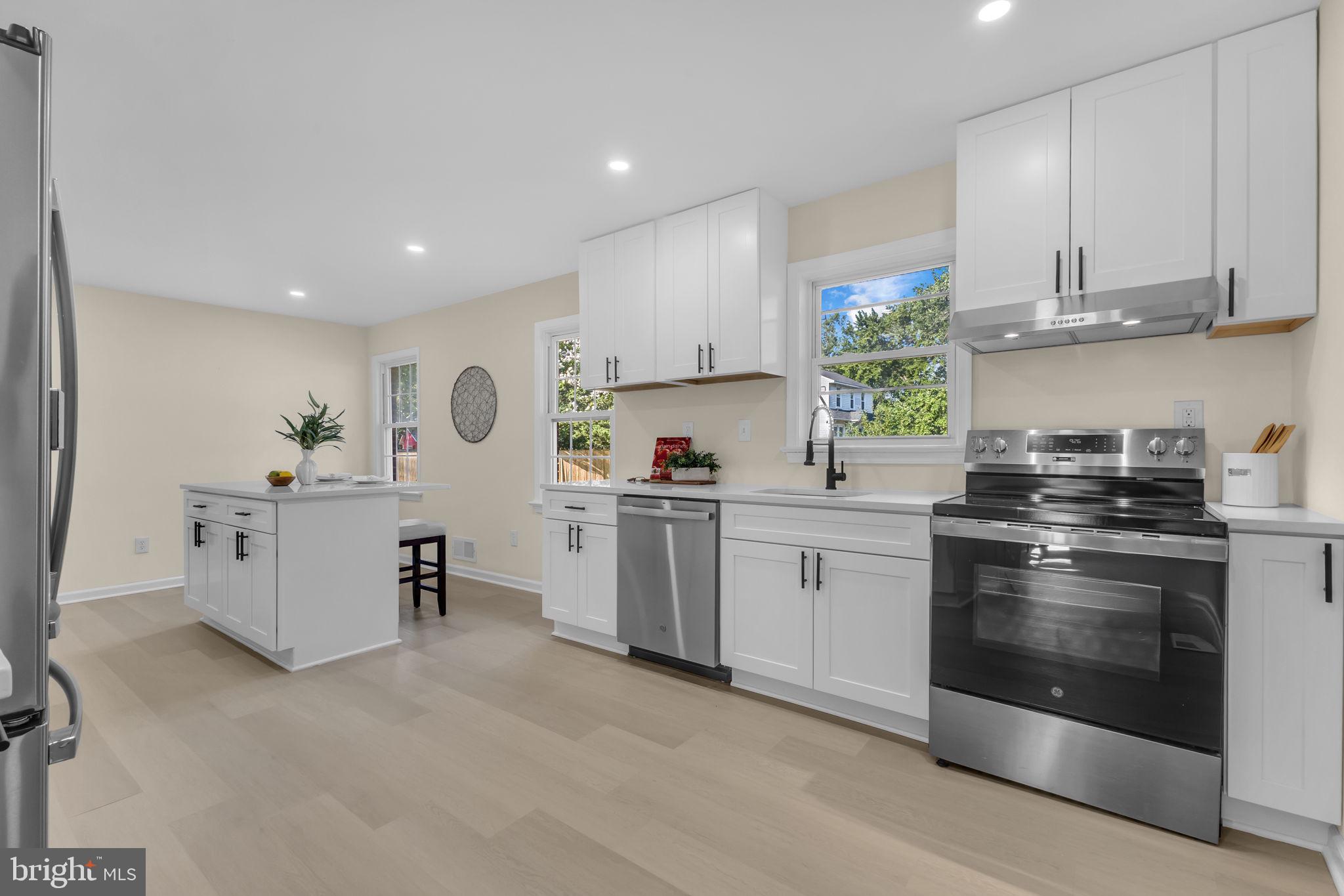 6400 Inwood Drive Springfield, VA 22150 - Photo 9 of 37 a kitchen with white cabinets stainless steel appliances and sink