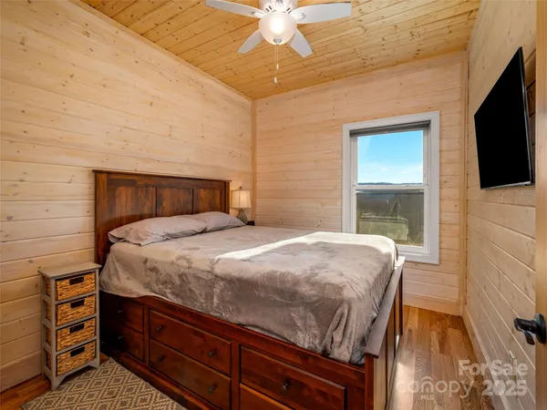 a bedroom with a bed and a flat screen tv