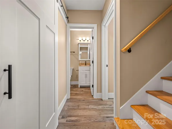 a view of a hallway with wooden floor and entryway