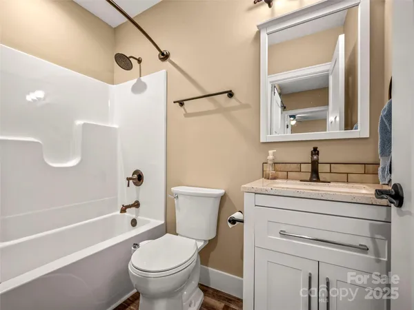 a bathroom with a granite countertop toilet a sink and a mirror
