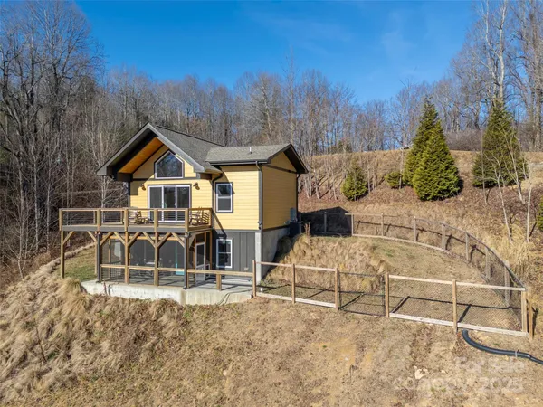 an aerial view of a house with large trees