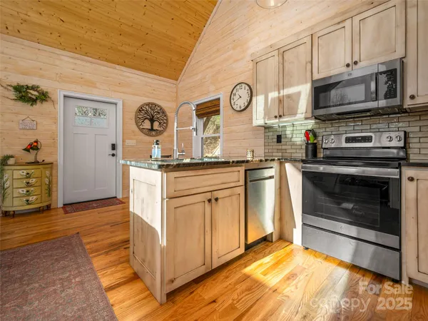 a kitchen with stainless steel appliances granite countertop a stove and a microwave