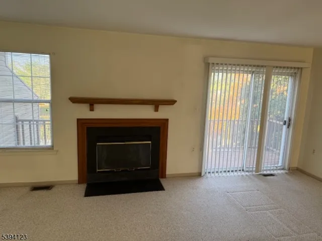 an empty room with windows and fireplace