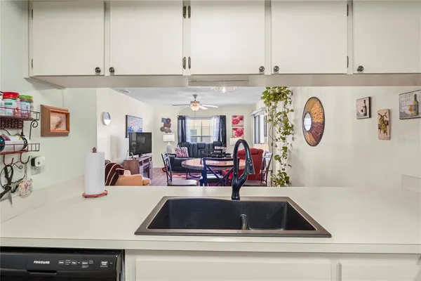 a kitchen with kitchen island granite countertop a sink a stove and a cabinets with wooden floor