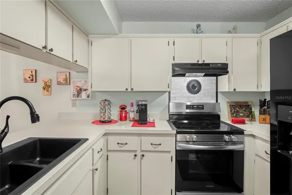 a kitchen with white cabinets and appliances