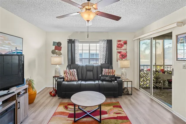 a living room with furniture a flat screen tv and a window
