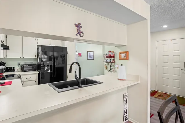a kitchen with stainless steel appliances kitchen island a refrigerator and sink