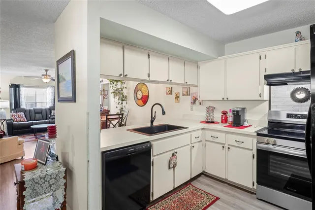a kitchen with white cabinets sink and white appliances
