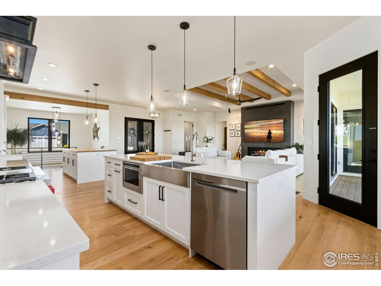 3802 Bridle Ridge Circle Severance, CO 80524 - Photo 14 of 50 a kitchen with stainless steel appliances kitchen island a stove a sink dishwasher and a fireplace with wooden floor