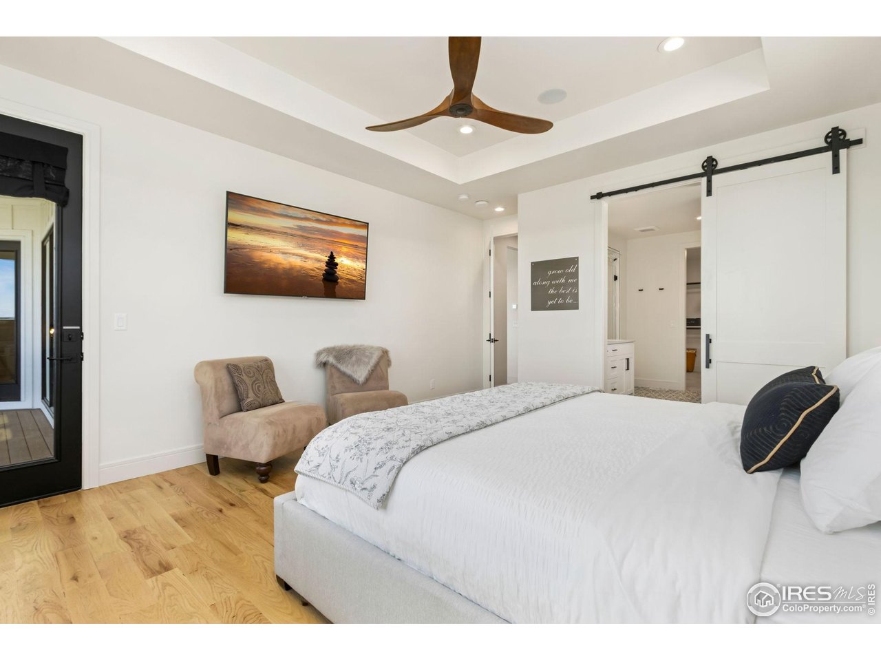 3802 Bridle Ridge Circle Severance, CO 80524 - Photo 19 of 50 a bedroom with a bed a couch and a flat tv screen on the dresser
