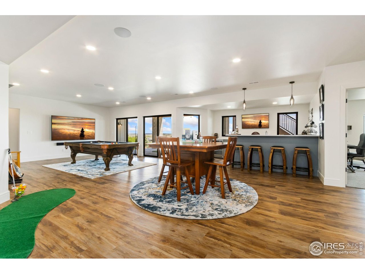 3802 Bridle Ridge Circle Severance, CO 80524 - Photo 29 of 50 a living room with kitchen view and a wooden floor