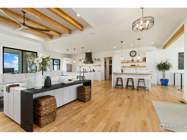 a living room with stainless steel appliances kitchen island granite countertop furniture a rug kitchen view and a chandelier