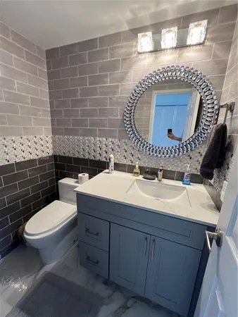 a bathroom with a sink mirror vanity and toilet