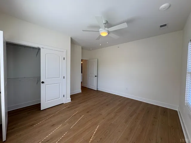 an empty room with wooden floor and natural light
