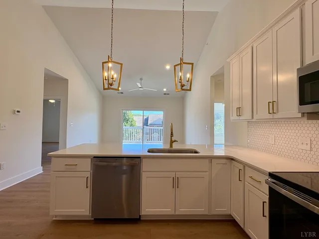 a kitchen with stainless steel appliances granite countertop a sink a stove and a wooden floors