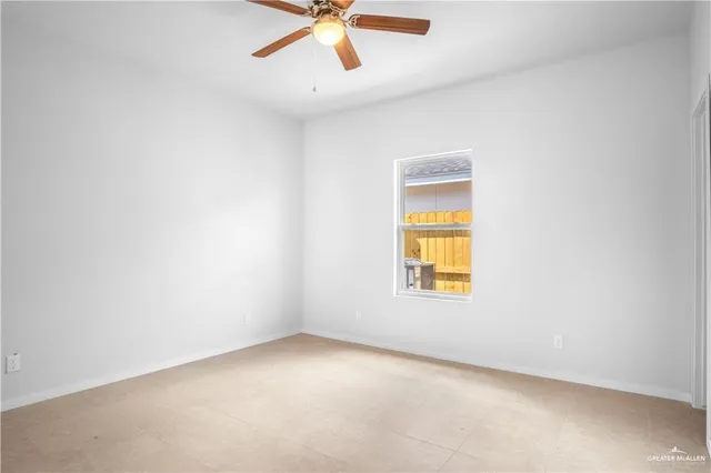 an empty room with a window and a fan
