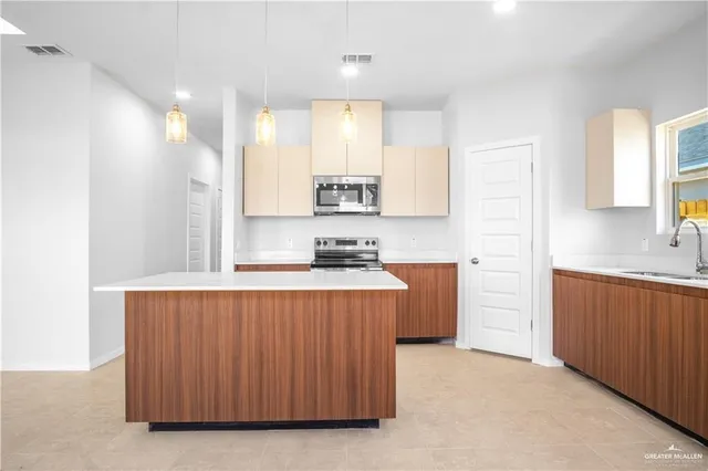 a kitchen with stainless steel appliances a sink stove and cabinets