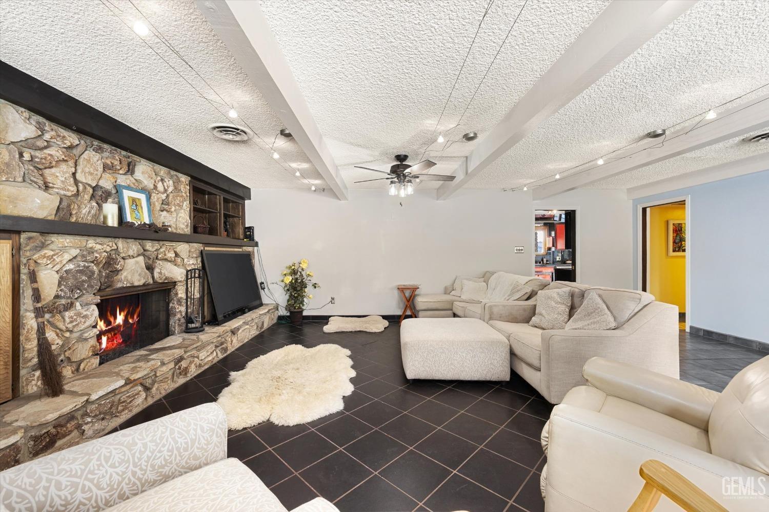 Undisclosed Address Bakersfield, CA 93306 - Photo 12 of 41 a living room with furniture a fireplace and a flat screen tv