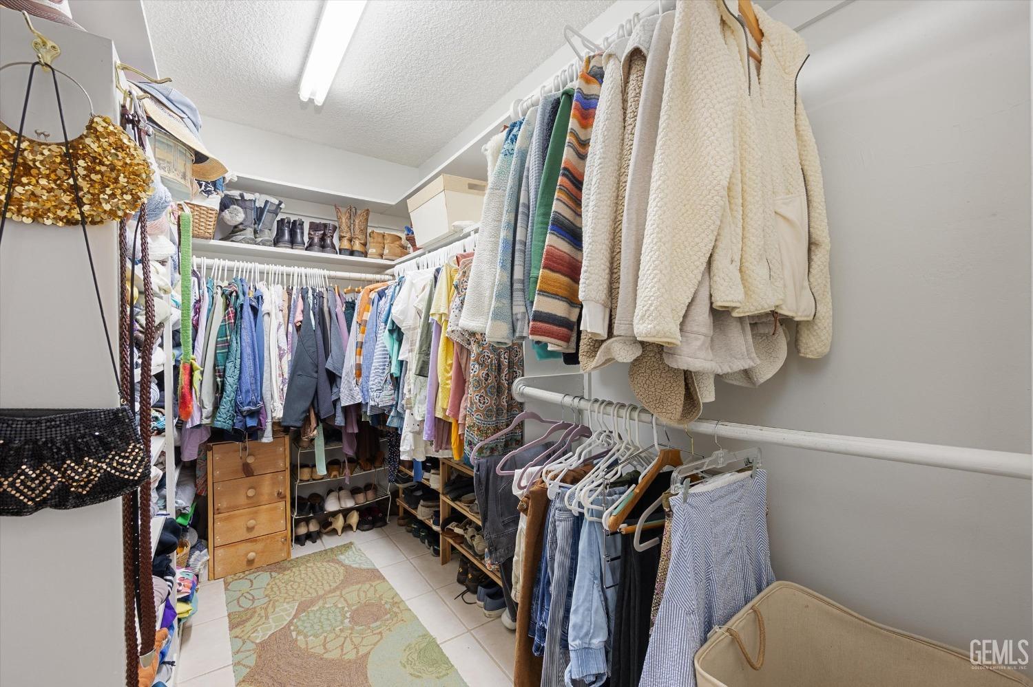 Undisclosed Address Bakersfield, CA 93306 - Photo 27 of 41 a view of walk in closet with clothes and shoes
