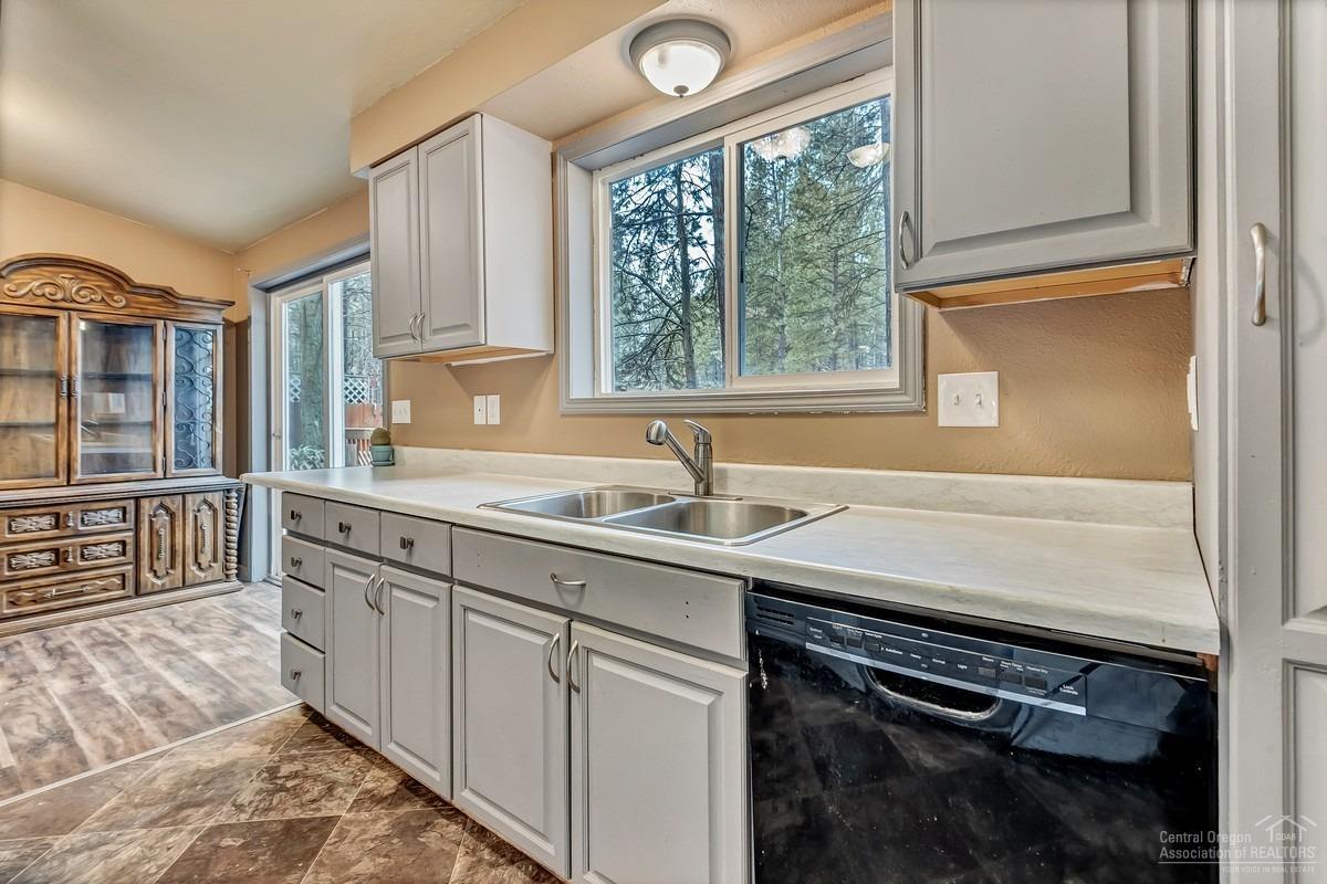 59757 Cheyenne Road Bend, OR 97702 - Photo 7 of 25 a kitchen with stainless steel appliances granite countertop a sink stove and cabinets