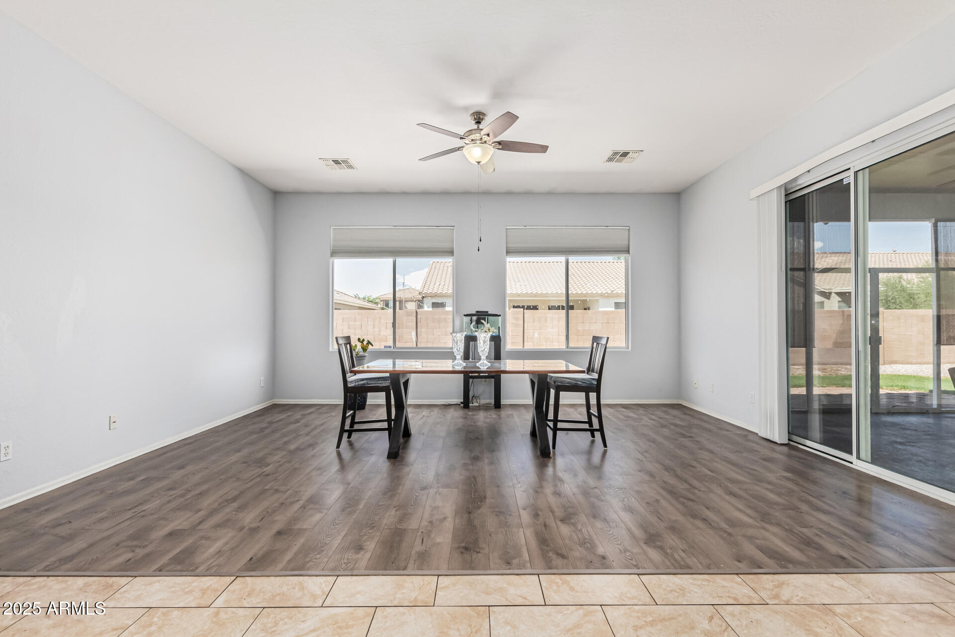 3318 West Latona Road Laveen, AZ 85339 - Photo 5 of 26 a dining room with wooden floor and white walls