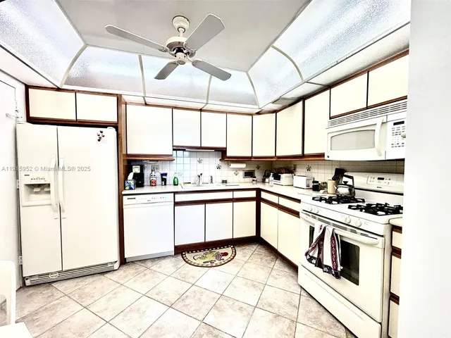a kitchen with stainless steel appliances kitchen island granite countertop a stove a sink and white cabinets
