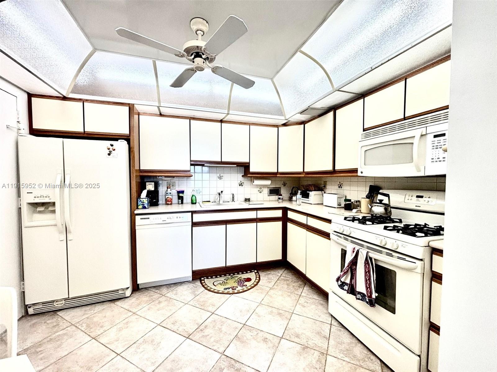 2030 South Ocean Drive, Unit 521 Hallandale Beach, FL 33009 - Photo 16 of 20 a kitchen with stainless steel appliances kitchen island granite countertop a stove a sink and white cabinets