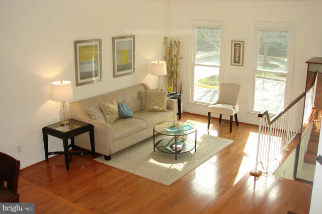 a living room with furniture and a table with wooden floor