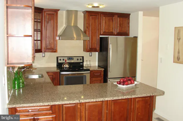 a kitchen with stainless steel appliances granite countertop a refrigerator and a stove