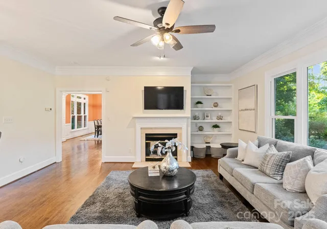a living room with furniture a fireplace and a large window