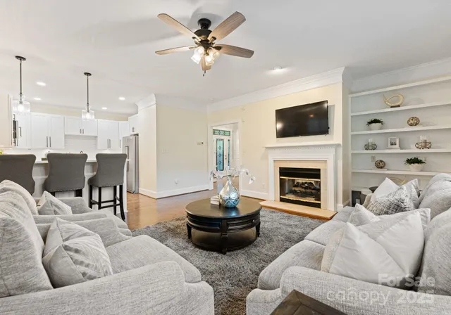 a living room with furniture a fireplace and a flat screen tv