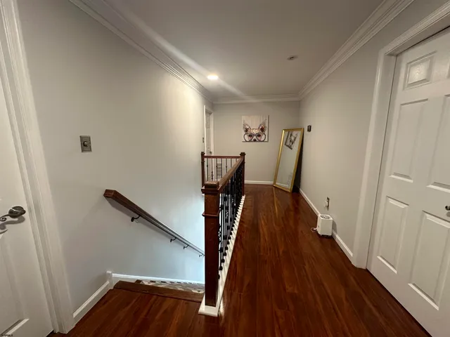 a view of a hallway with wooden floor and stairs