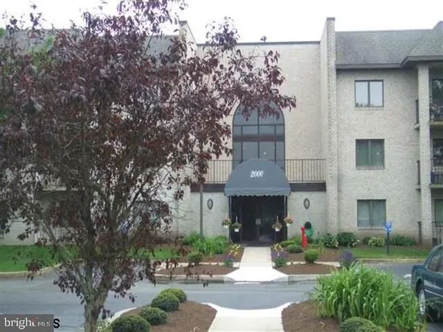 a front view of a house with garden and trees