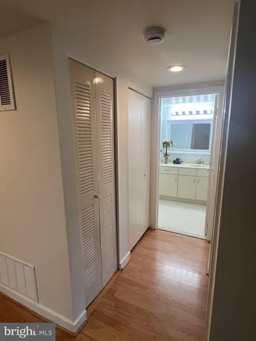 a view of hallway with bathroom and a sink
