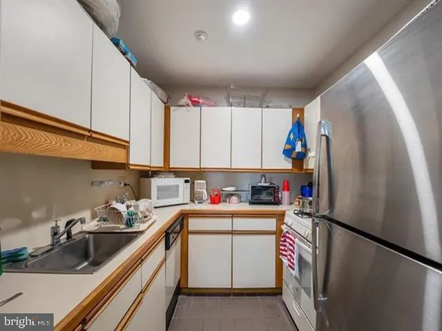 a kitchen with a sink a refrigerator and cabinets