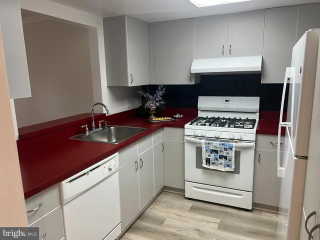 a kitchen with stainless steel appliances a sink stove and cabinets