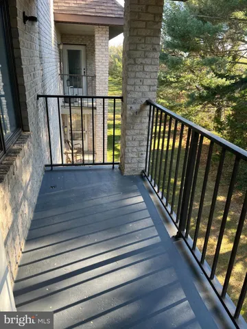 a view of a balcony with wooden floor and fence