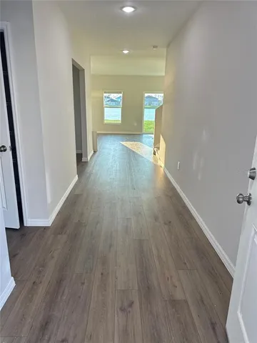 a view of a hallway with wooden floor