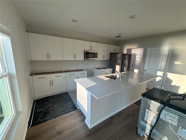 a kitchen with a sink cabinets and wooden floor