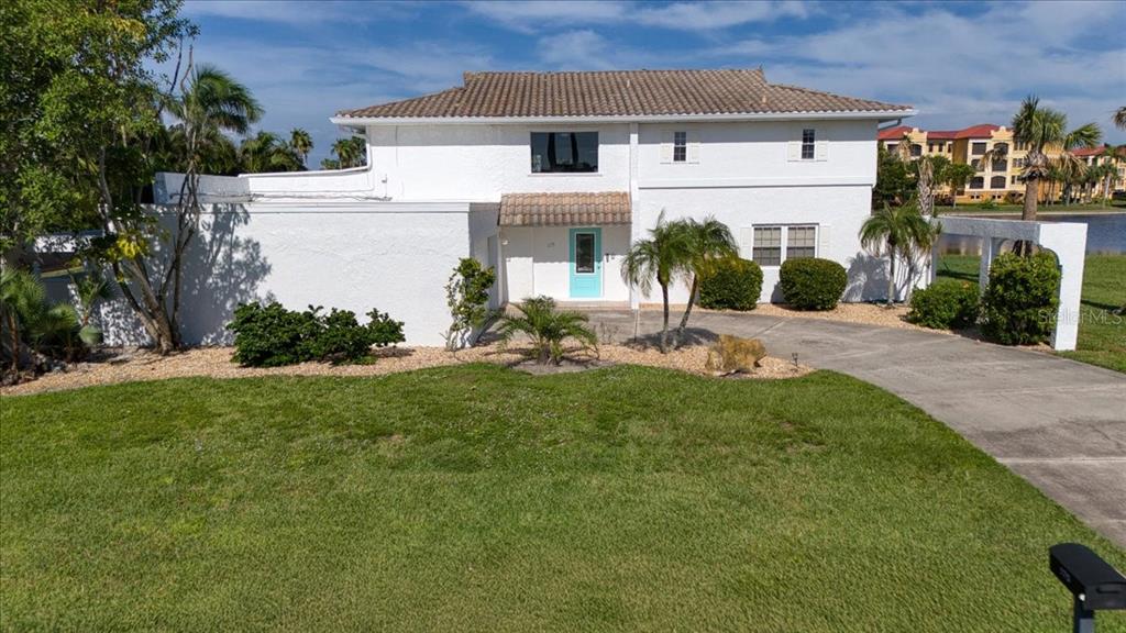 a front view of a house with a yard and potted plants