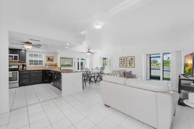 a large living room with stainless steel appliances kitchen island granite countertop furniture and a living room