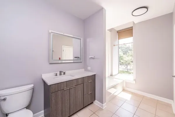 a bathroom with a toilet sink and mirror