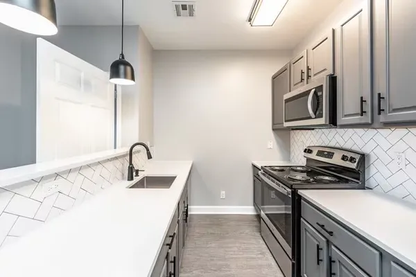 a kitchen with stainless steel appliances granite countertop a sink stove and microwave