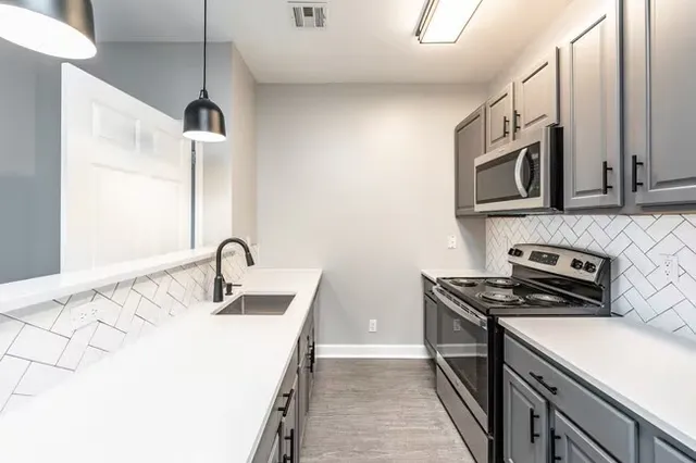 a kitchen with stainless steel appliances granite countertop a sink stove and microwave