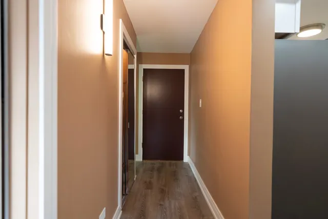 a view of a hallway with wooden floor