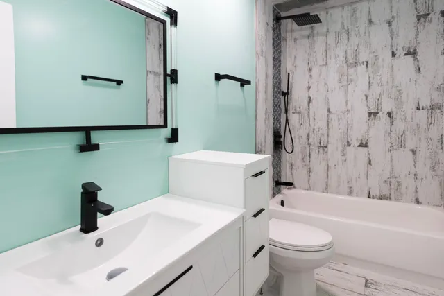 a bathroom with a sink a toilet and shower