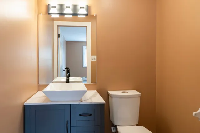 a bathroom with a sink a toilet and mirror